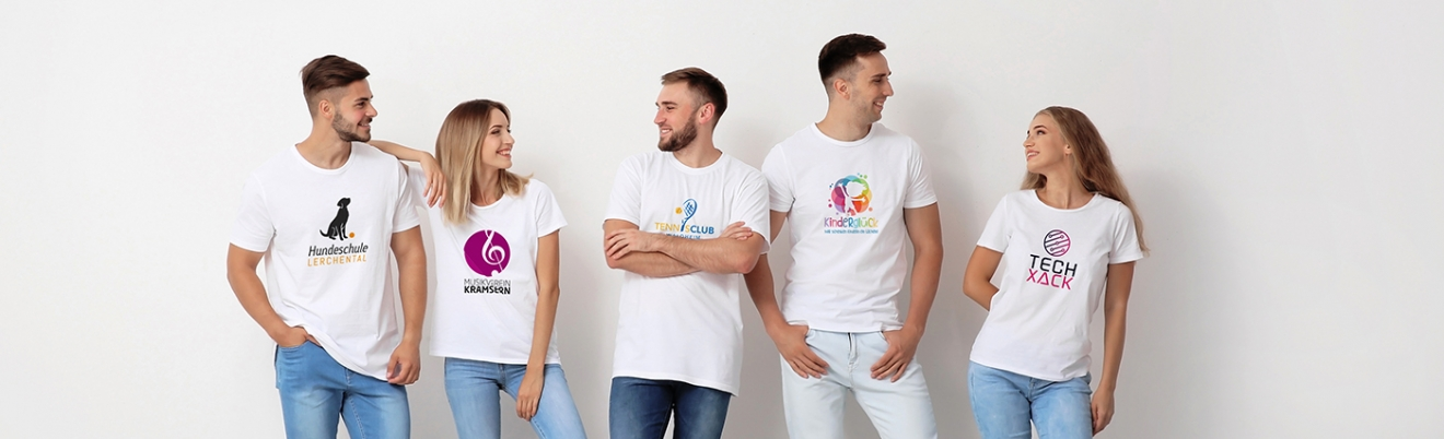 Fünf junge Erwachsene in weißen T-Shirts mit verschiedenen bunten Logos stehen vor einer weißen Wand, lächeln und schauen sich an.