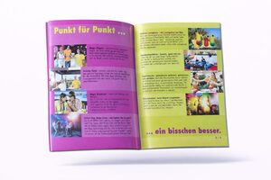 Ein aufgeschlagenes Magazin mit bunten Seiten mit deutschem Text, Fotos von Menschen, die an Aktivitäten teilnehmen, und Bildern von Speisen und Getränken. Die linke Seite ist lila und gelb; die rechte Seite ist gelb mit mehreren Bildern und Text.