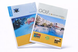 Abgebildet sind zwei Broschüren. Die linke Broschüre zeigt Tauchen und Unterwasserszenen, während die rechte Broschüre für Golf im Manar Imperial in Tunesien wirbt und einen Pool und ein Resortgebäude mit Palmen zeigt.
