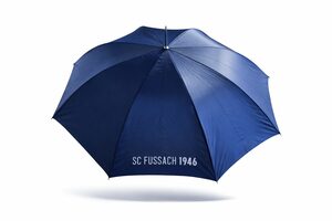 Ein großer blauer Regenschirm mit dem Text SC FUSSACH 1946 in weißer Schrift auf einem Feld vor einem schlichten weißen Hintergrund.