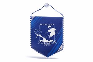 Ein blauer Wimpel mit weißem Rand und einer Aufhängekordel mit dem Logo des Sportclubs Fussach 1946 und der Abbildung eines Fußballspielers, der einen Ball schießt.
